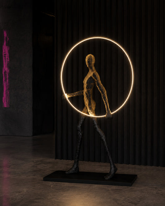 ORBIT WALKER — Drop 028 sculptural halo floor light in a dark gallery